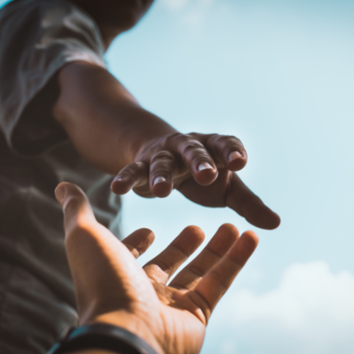 one hand reaching for another