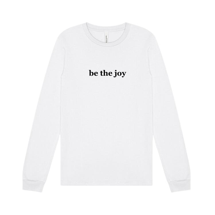 white long sleeve tee emblazoned with the phrase be the joy.