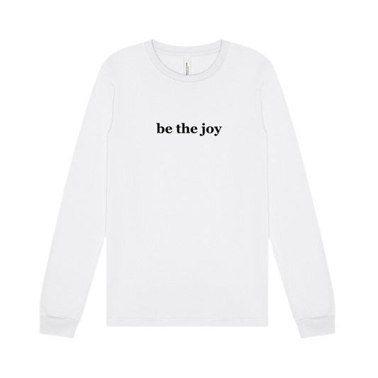 white long sleeve tee emblazoned with the phrase be the joy.